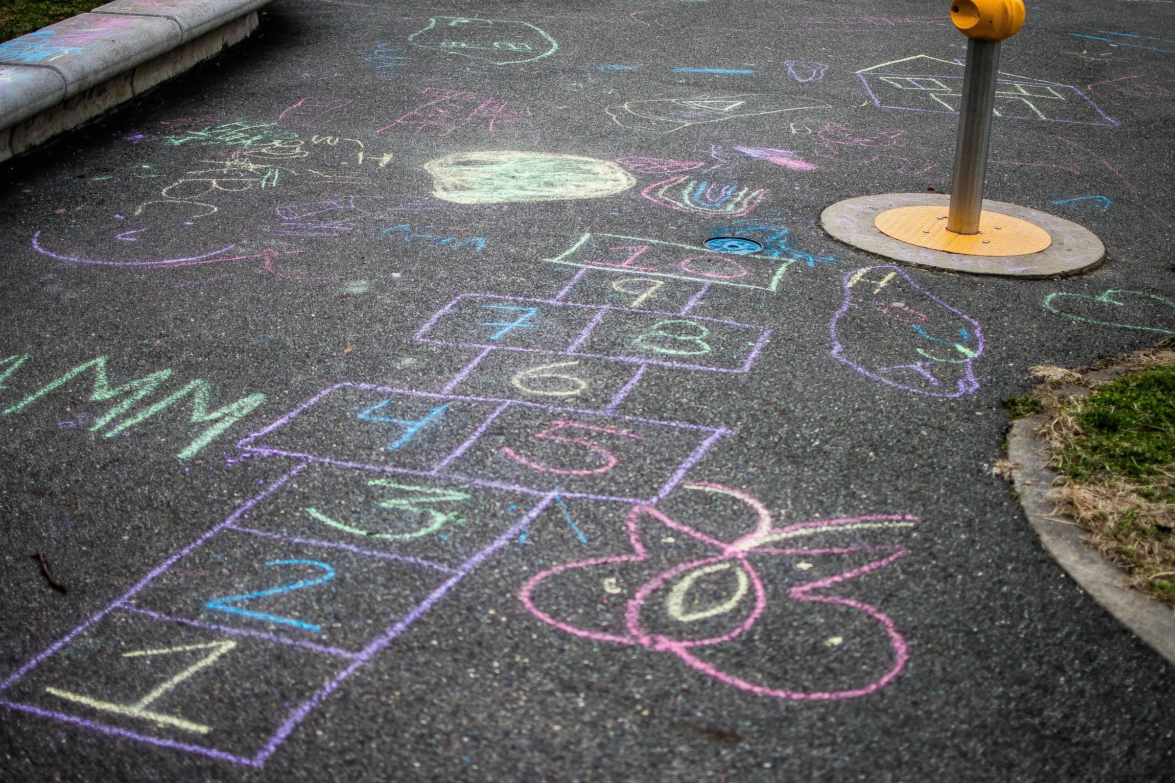 Children's chalk hopscotch grid drawn on a sidewalk in Queens, numbered squares mapping a path forward.